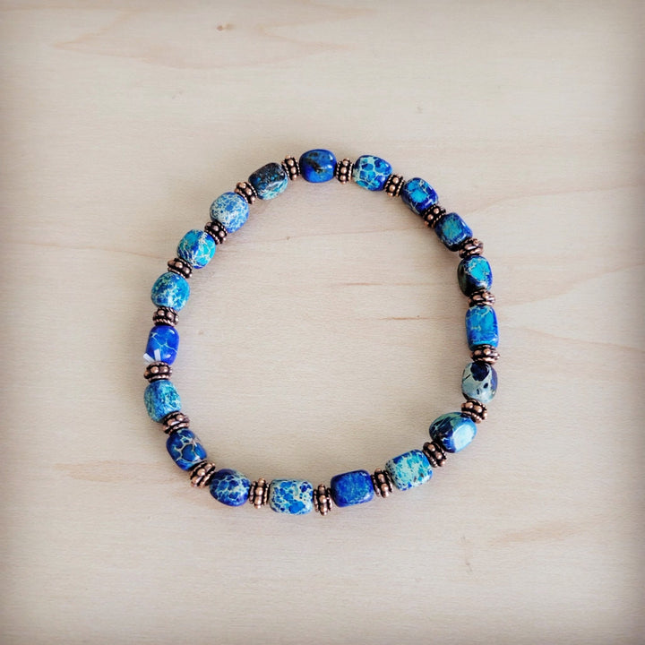Blue beaded stretch bracelet with copper-toned spacers and round blue stones detail