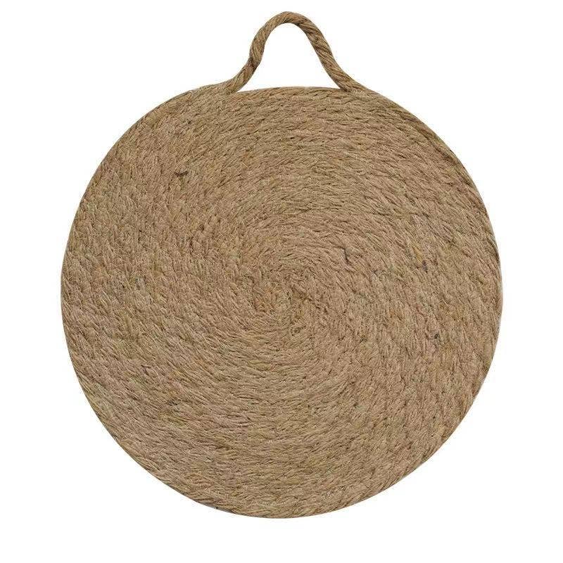 Round woven natural trivet with top handle loop, smooth woven texture visible