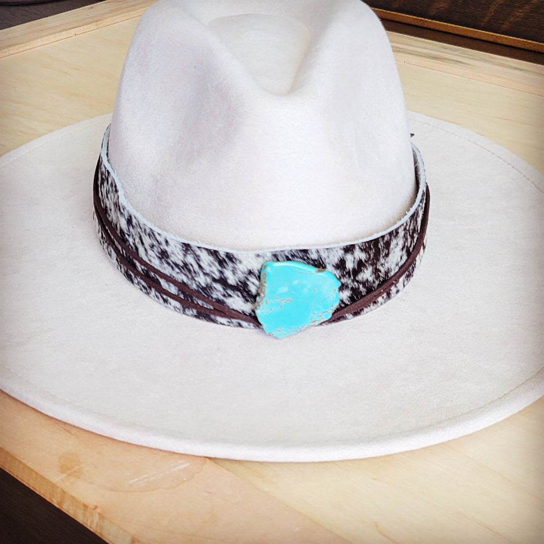 Wide-brim white hat with black spotted leather band and turquoise heart buckle