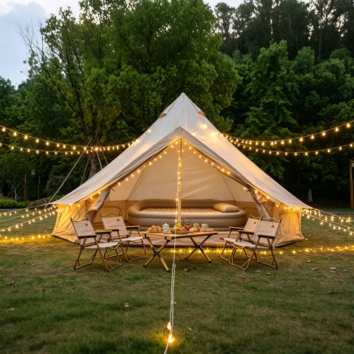 Beige bell glamping tent with string lights and cushioned seating inside