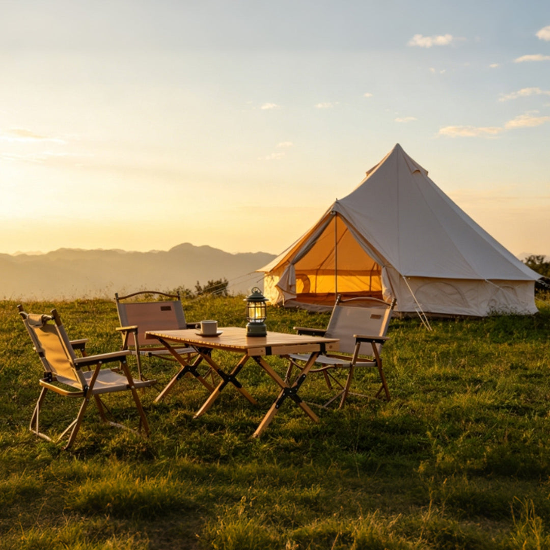 Bell tent campsite setup with open doorway, outdoor table and chairs, beige canvas