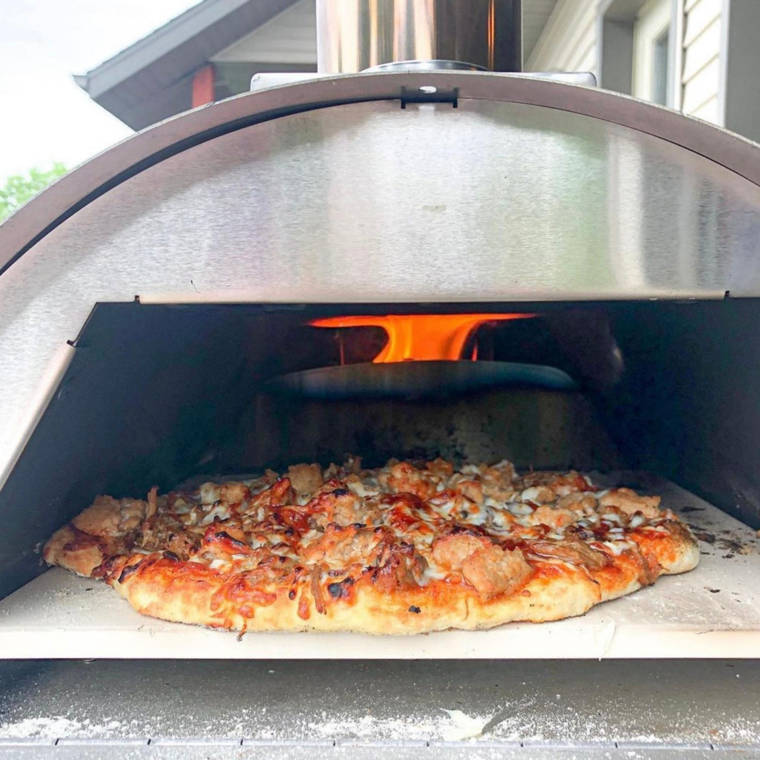 Pizza on cordierite stone inside portable oven, ready to bake