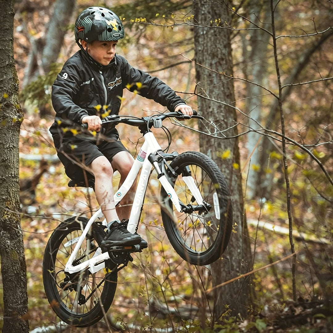 Kids 20-inch mountain bike being ridden by a child, with front suspension and thick tread tires
