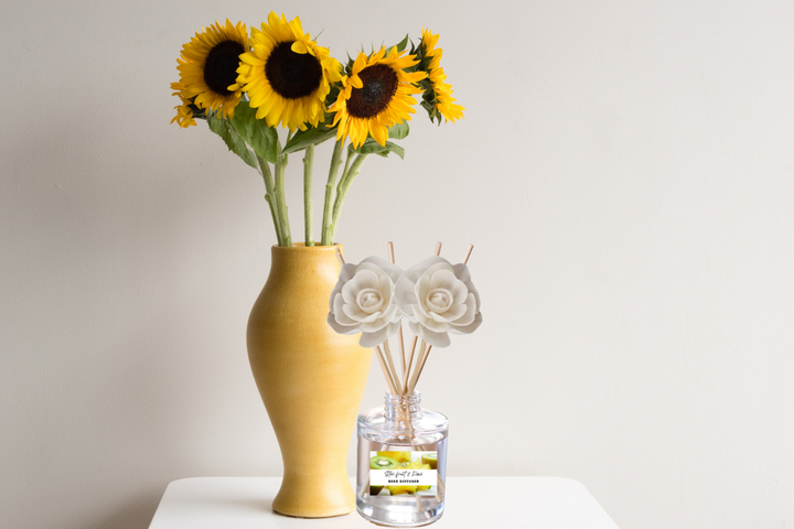 Reed diffuser set with wooden reeds in clear glass bottle, sunflower and rose decoration