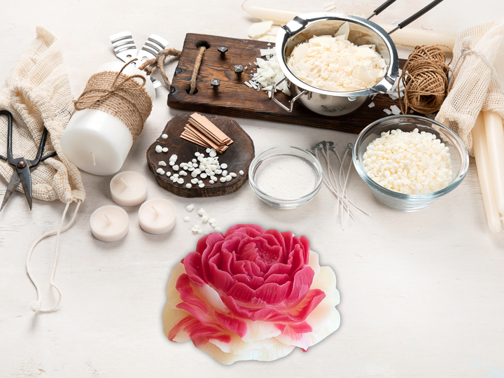 Pink and cream wax flower freshener on a tabletop with small wax pieces