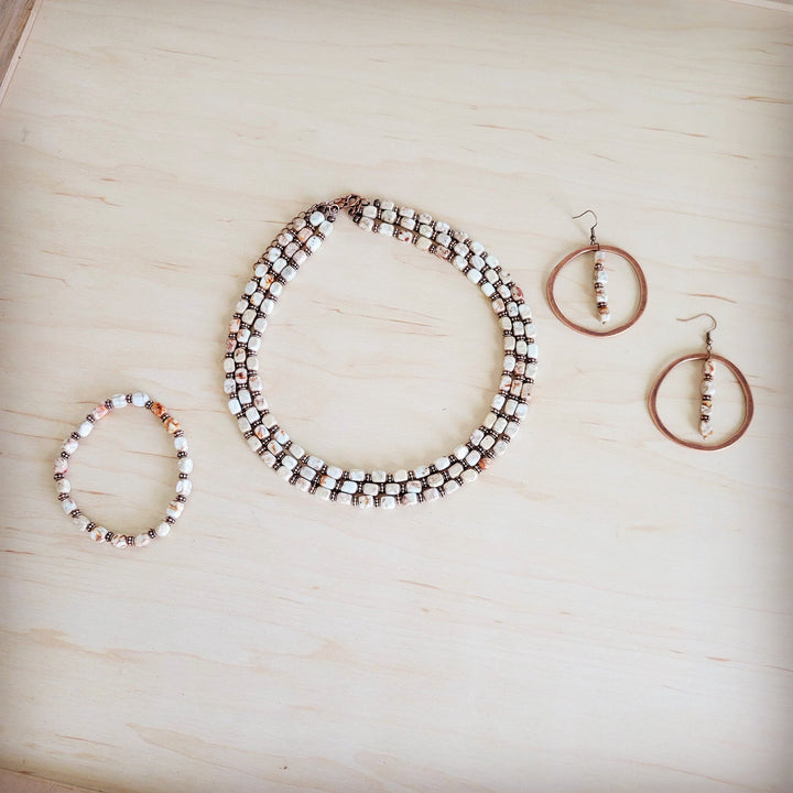 Pair of copper hoop earrings with bead-stacked drops and dangling white accents