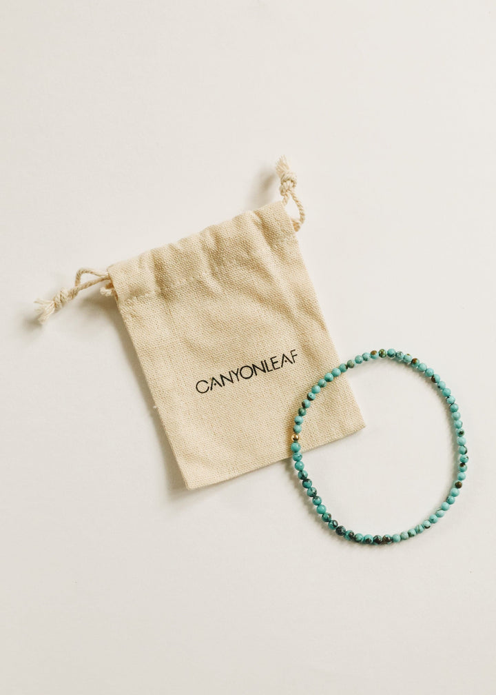 Turquoise bead anklet with pouch, showing gold-tone bead details