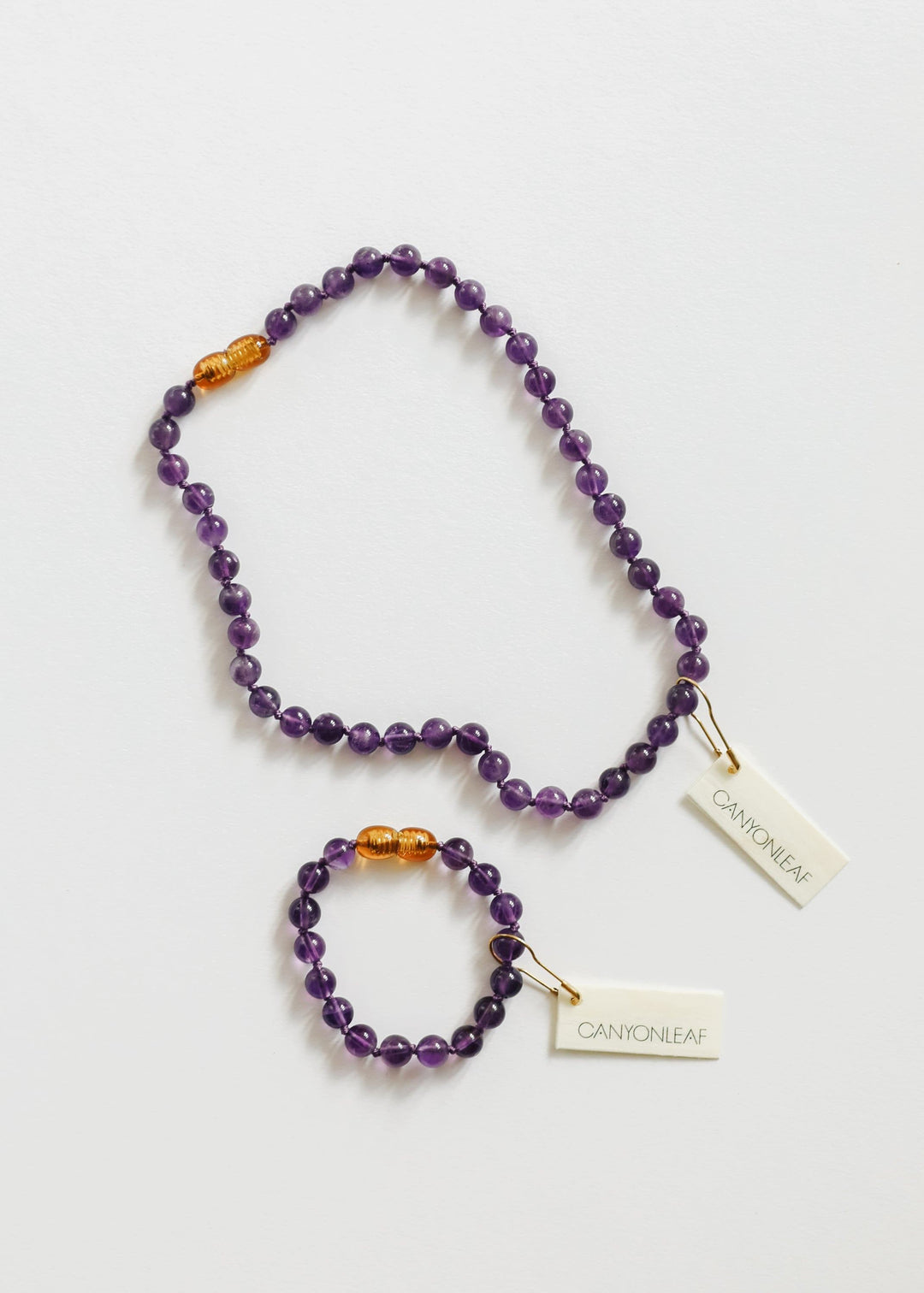 Amethyst bead necklace with mini hoop earrings, orange spacer beads, brand tags