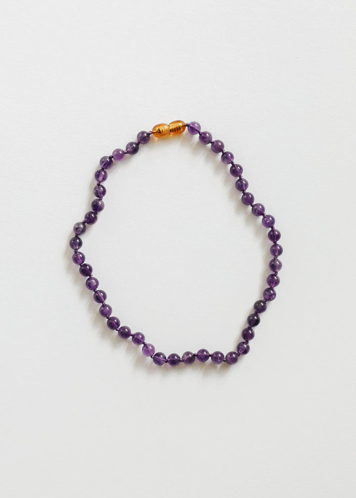 Amethyst bead necklace with a single orange spacer bead
