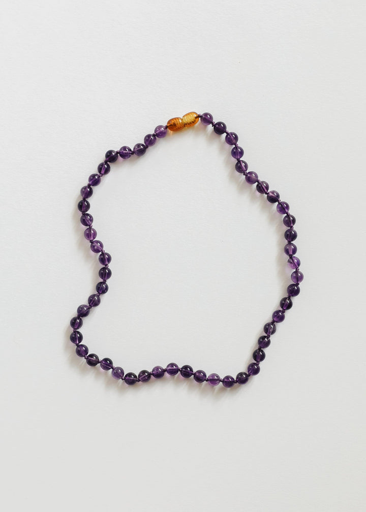 Amethyst bead necklace with orange spacer beads at the top