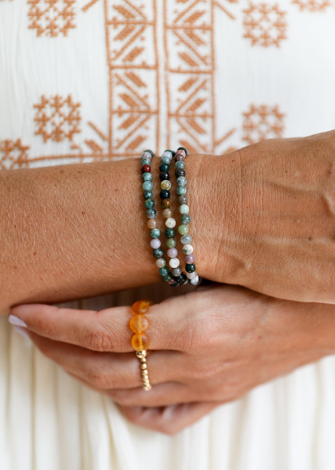 Adult beaded agate bracelet on wrist, dark green, black, and brown beads