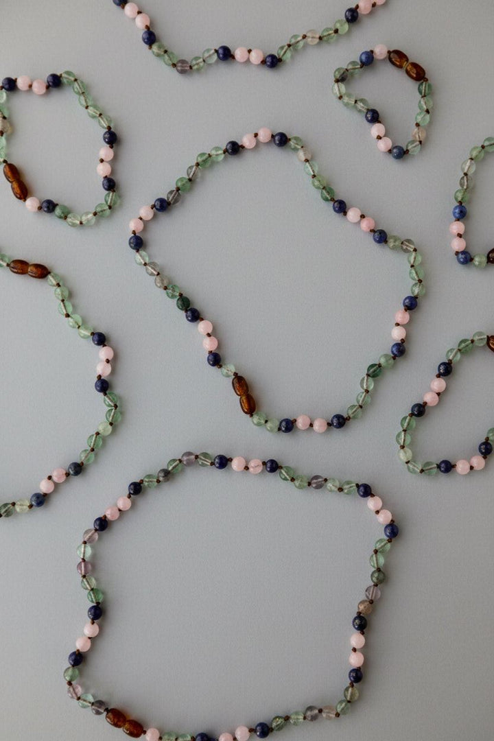 Multicolor gemstone bead necklace displayed in multiple angles, small oval beads
