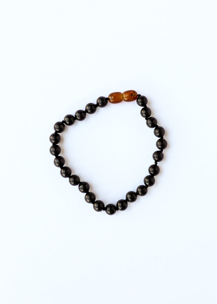 Shungite bead bracelet with dark round beads and one amber center bead