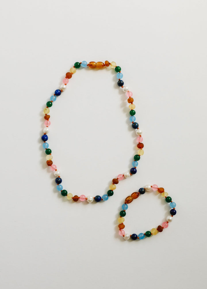 Two beaded bracelets together, multicolor round beads with white pearls and pink accents