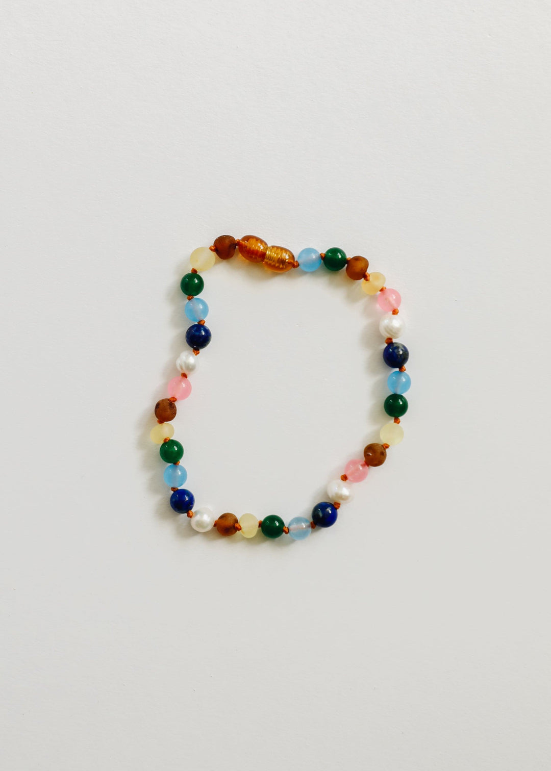 Beaded bracelet with orange center bead, green and blue beads, white pearls, pink accents