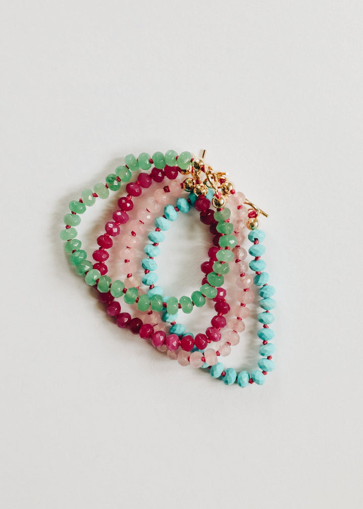 Multicolor beaded toggle necklace with green, red, and turquoise round faceted beads.