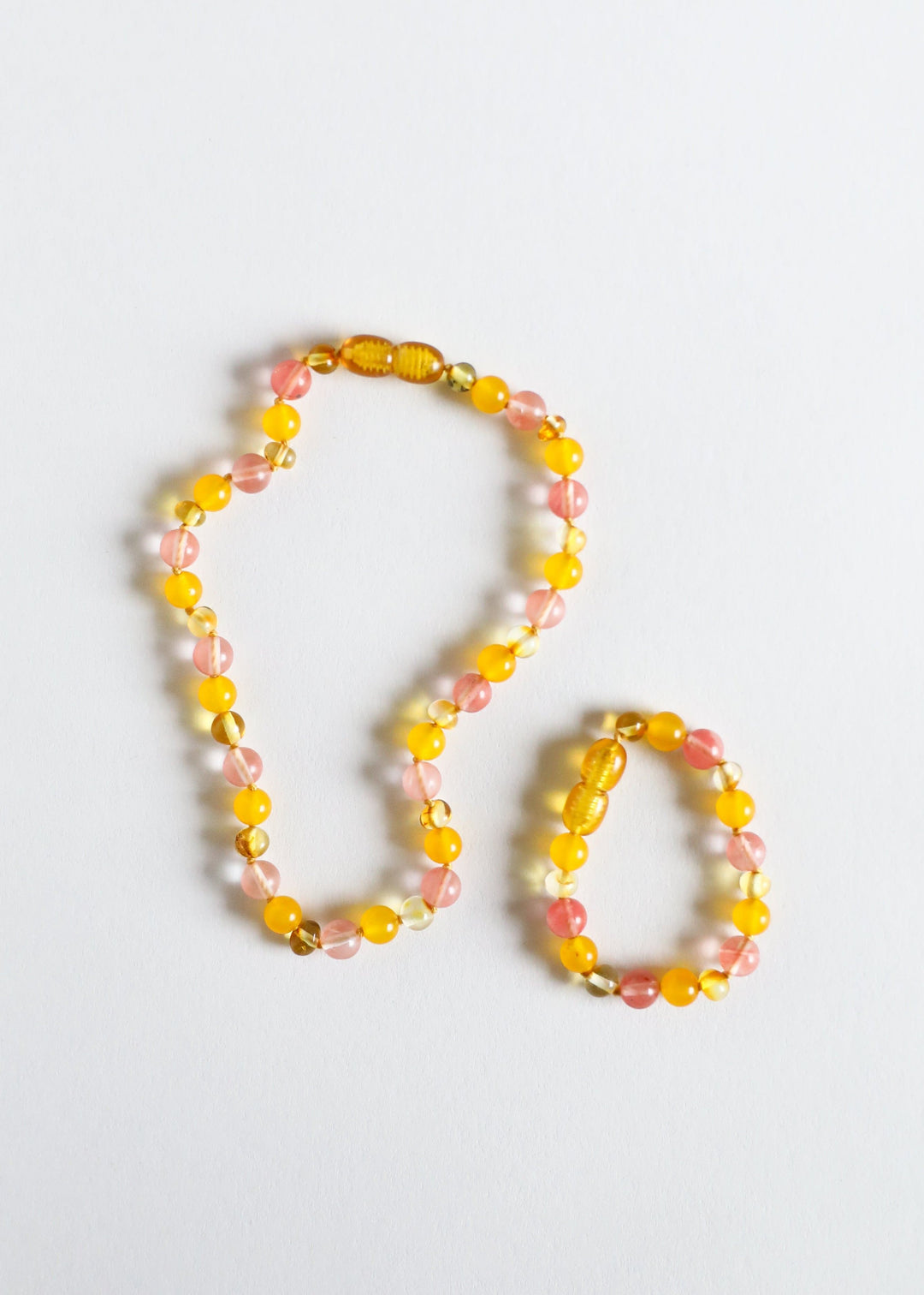 Beaded necklace with golden yellow and pink gemstone beads, shown alongside a shorter matching loop