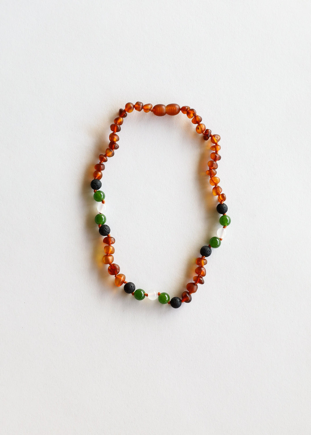 Amber bead necklace with green and black accent stones, round beads