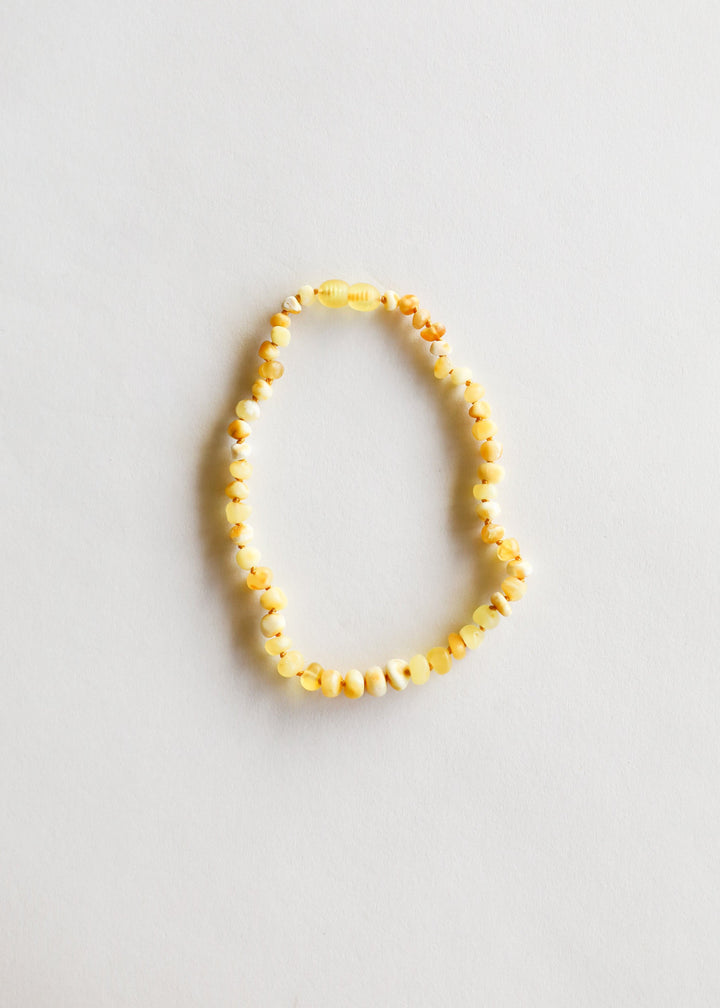 Yellow amber bead necklace laid in an oval shape