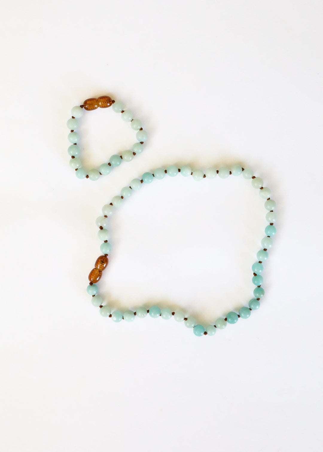 Amazonite beaded necklace with light blue beads and two amber accent beads at ends