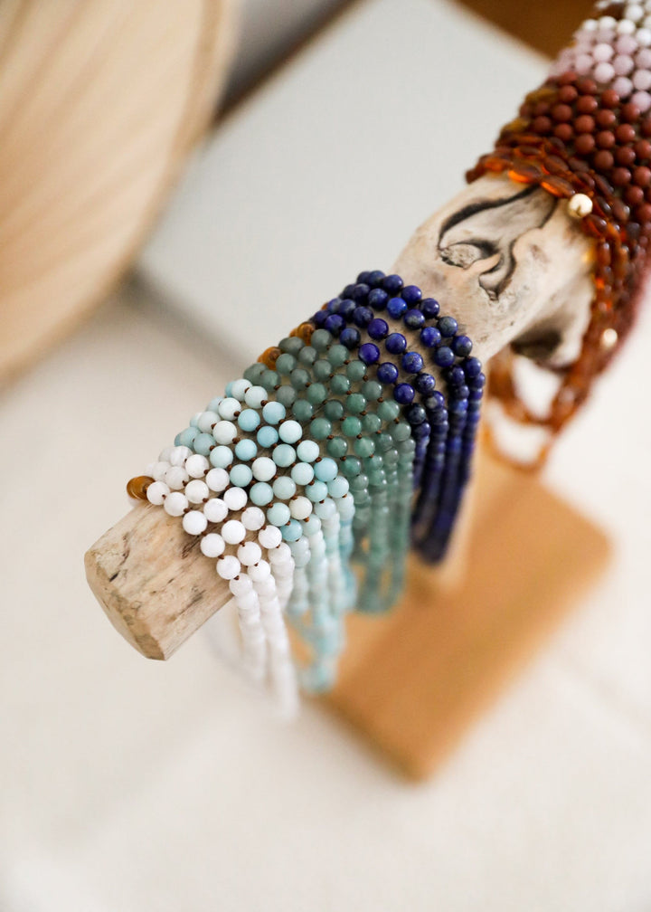 Beaded gemstone necklace strand with turquoise and dark blue beads and brown wooden clasp