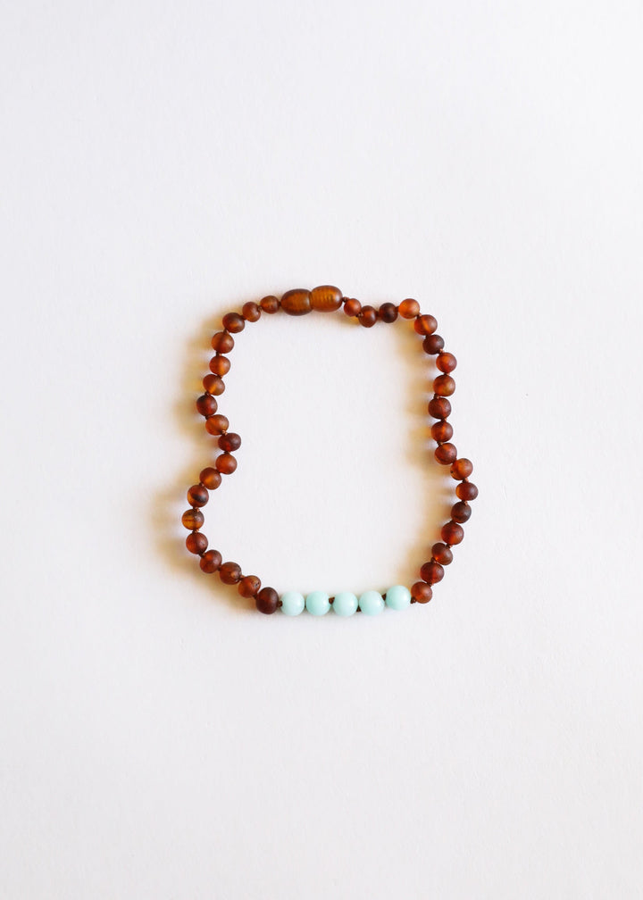 Beaded amber necklace with small turquoise stones along the bottom edge