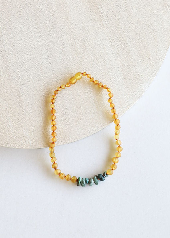 Amber bead necklace with raw turquoise stone accents.
