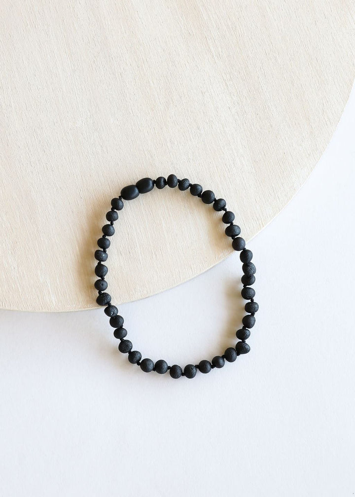 Black amber bead necklace with tightly strung round beads