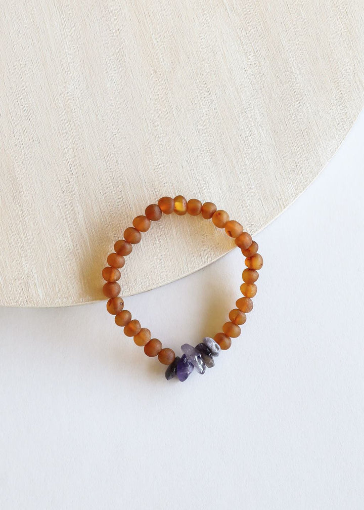 Amber-brown bead bracelet with small purple amethyst pieces on white