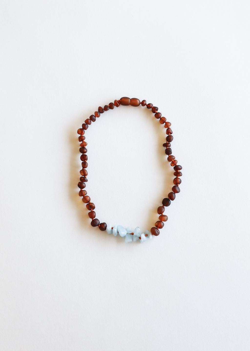 Amber brown beaded necklace with light blue stones along the front
