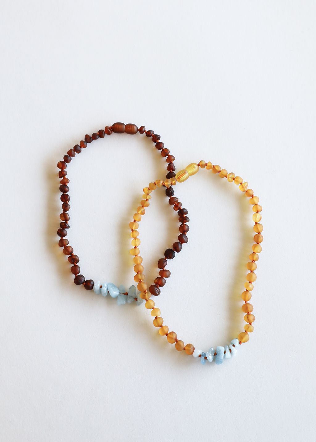 Amber brown bead necklace with light blue stone accents, knotted strand design