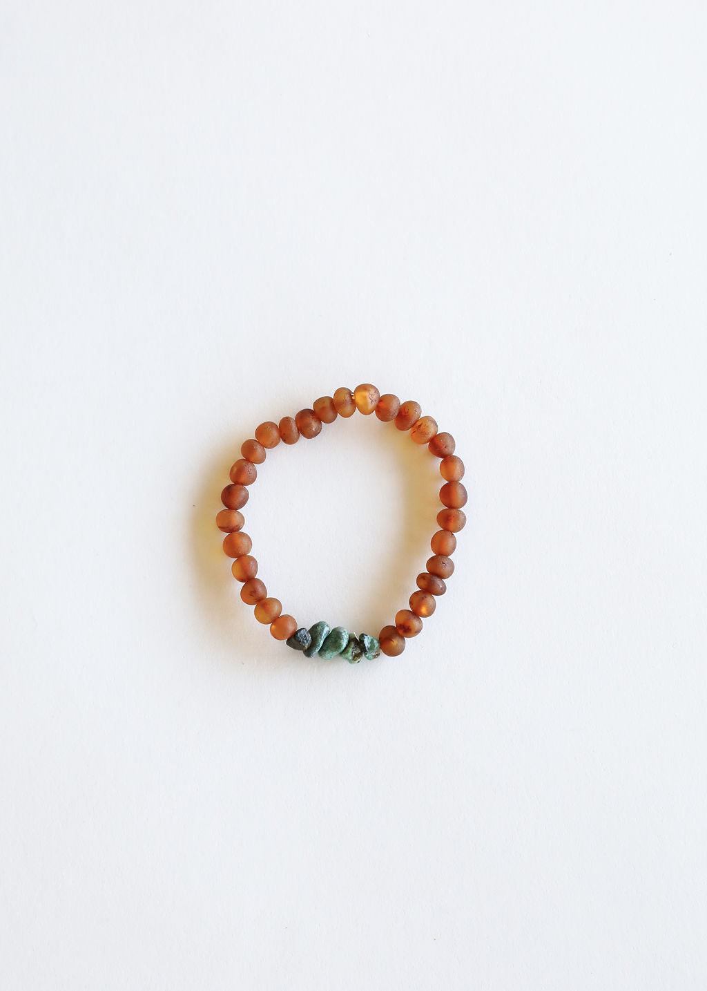 Amber-brown beaded bracelet with green turquoise stones, flat lay