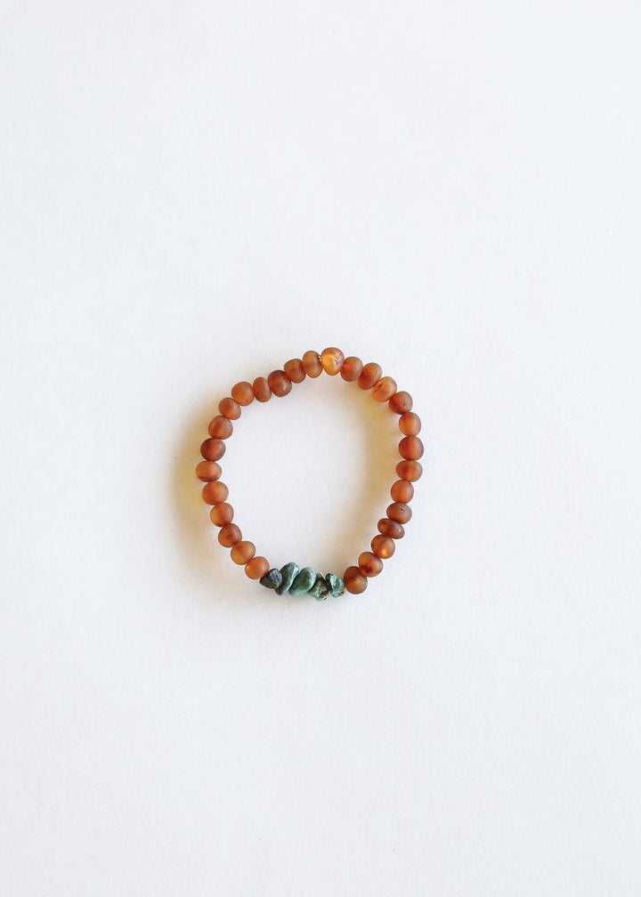 Amber-brown beaded bracelet with green turquoise stones, flat lay
