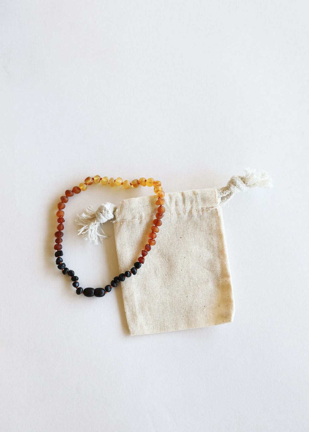 Ombre amber bead necklace with drawstring fabric pouch and tassel