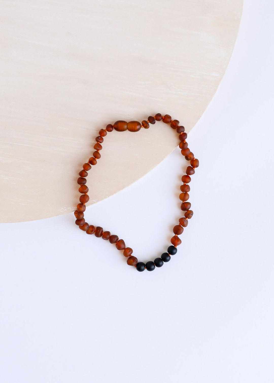 Cognac amber bead necklace with small black beads at the lower edge