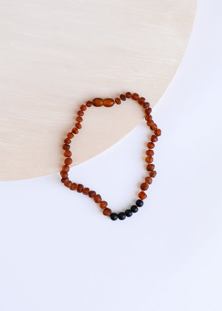 Cognac amber bead necklace with small black beads at the lower edge