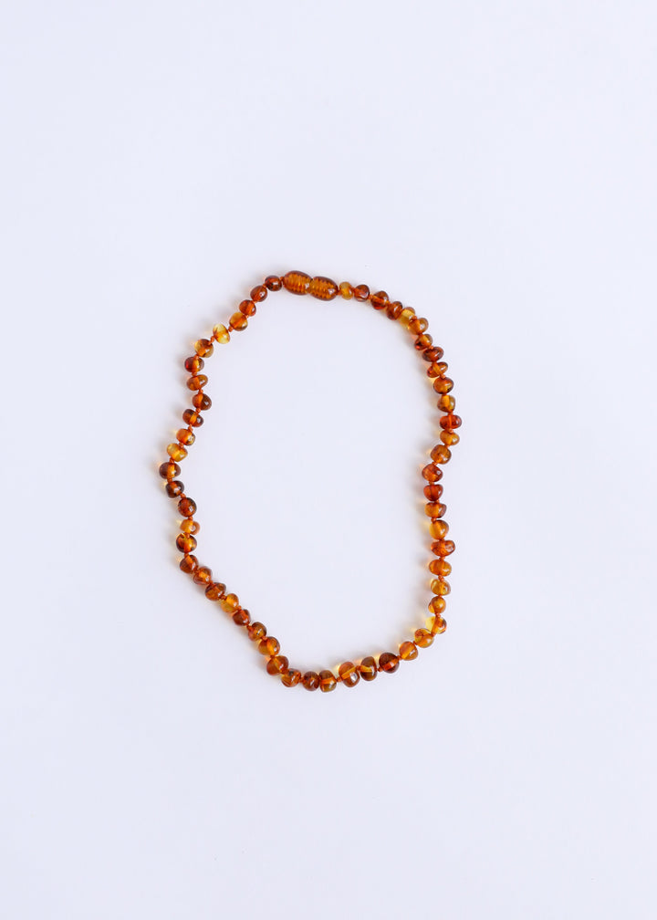 Single-strand amber bead necklace of round polished beads in warm cognac tones