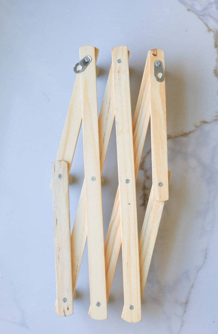 Wall-mounted wooden coat rack showing mounting brackets and angled hooks