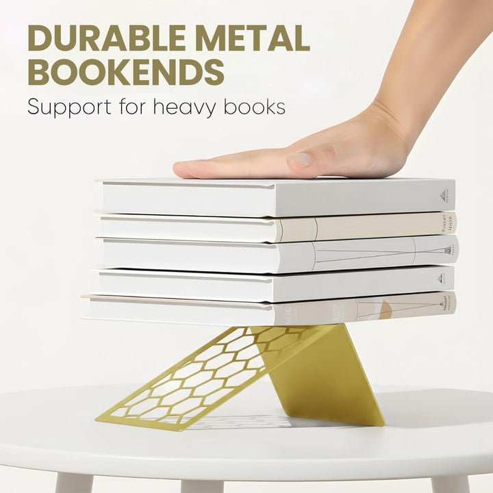 Gold honeycomb metal bookend supporting a stack of books on a tabletop.
