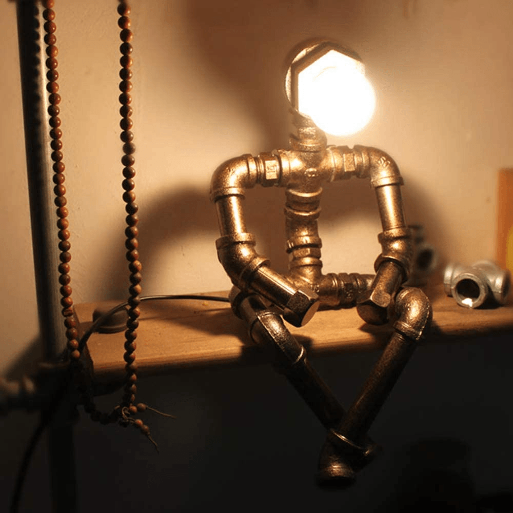 Gold-toned steampunk table lamp with glowing round Edison bulb and pipe frame