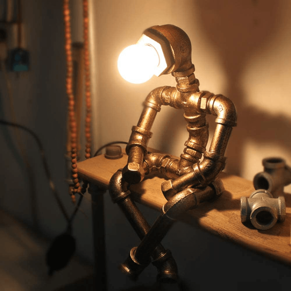 Bronze steampunk table lamp with lit Edison bulb and curved pipe legs on shelf