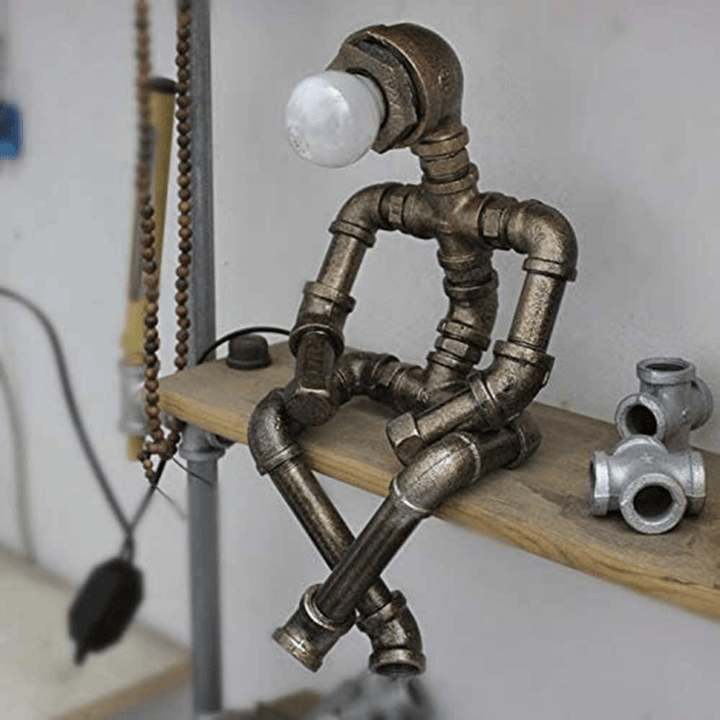 Dark metal steampunk table lamp with frosted bulb cap and pipe frame on wooden shelf