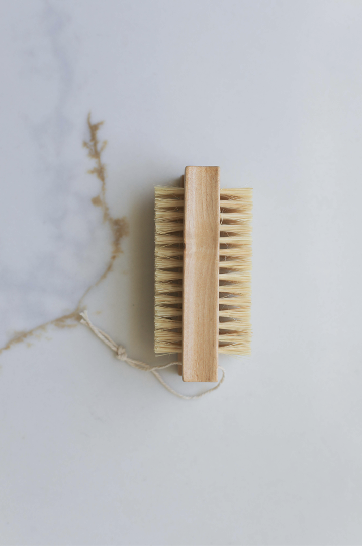 Double-sided nail brush with wooden handle and tan bristles on both sides