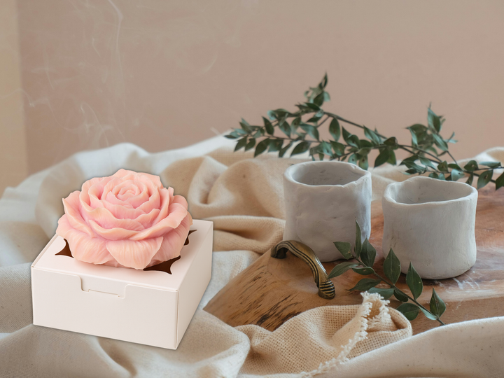 Scented wax flower freshener bloom on a shelf with fabric and small stone cups