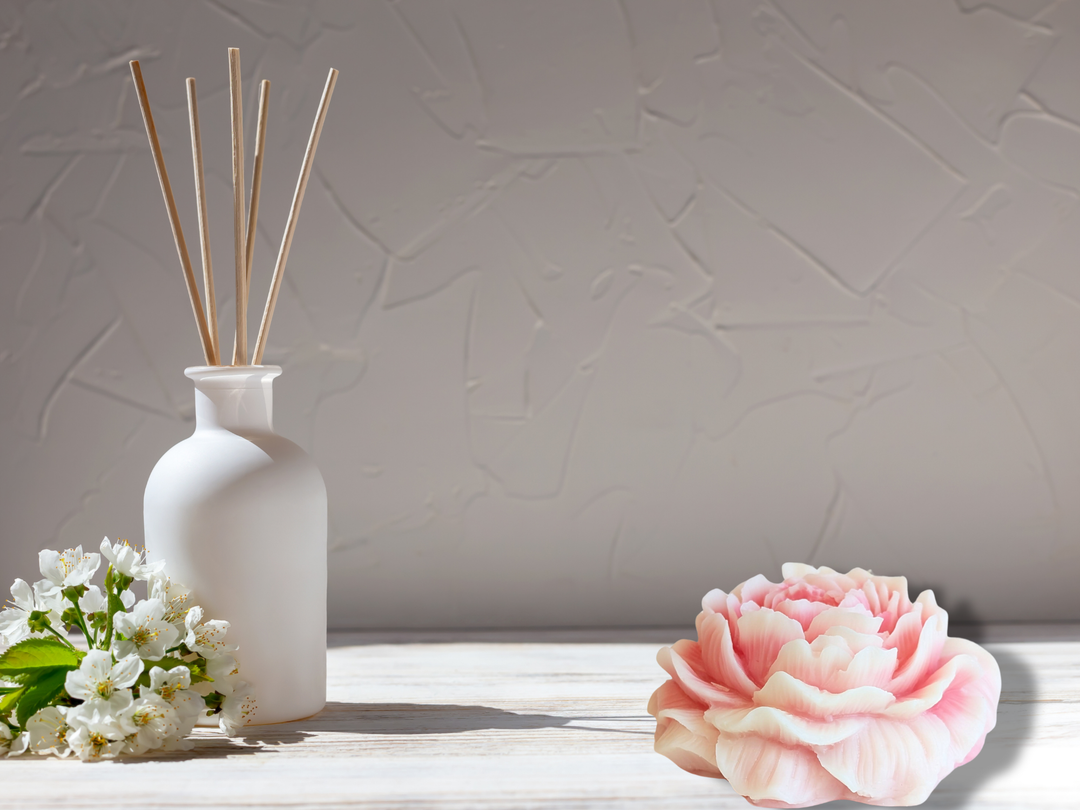 Scented wax flower freshener bloom with rose-pink petals on a light tabletop