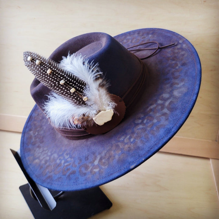 Navy blue leopard-print felt cowgirl hat with feather and beaded hatband