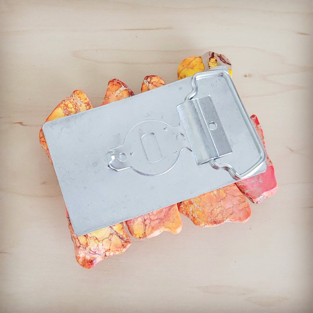Silver belt buckle with engraved face and orange Regalite slab inlay