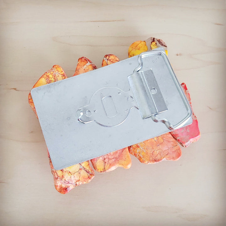 Silver belt buckle with engraved face and orange Regalite slab inlay