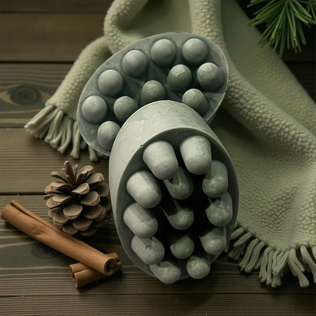 Green-toned massage bar soap with rounded nodules in an oval dish