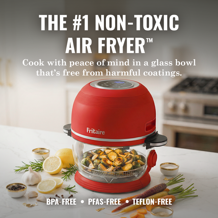 Cherry red air fryer with clear glass bowl holding food pieces on base